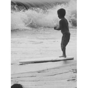  Little Boy Standing on a Surf Board Staring at the Water 